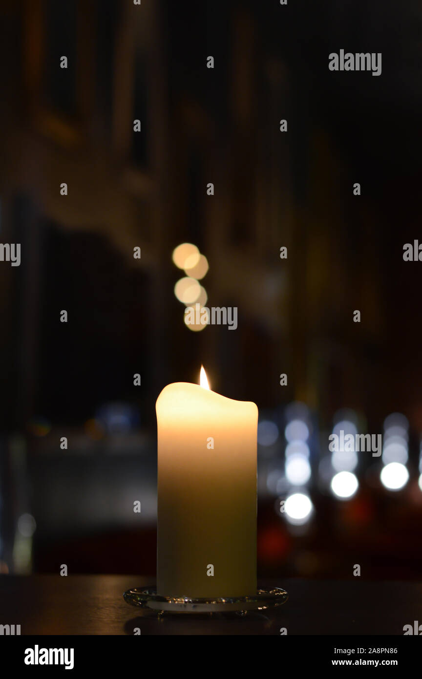 Una candela con un bellissimo bokeh e sfocata riflessi di luce Foto Stock