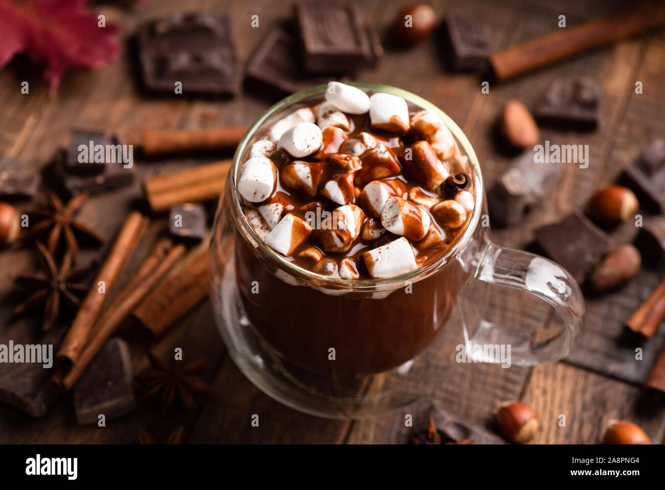La tazza di cioccolata calda con marshmallows e cannella su un marrone tavolo in legno. Comfort food, bevanda di Natale Foto Stock
