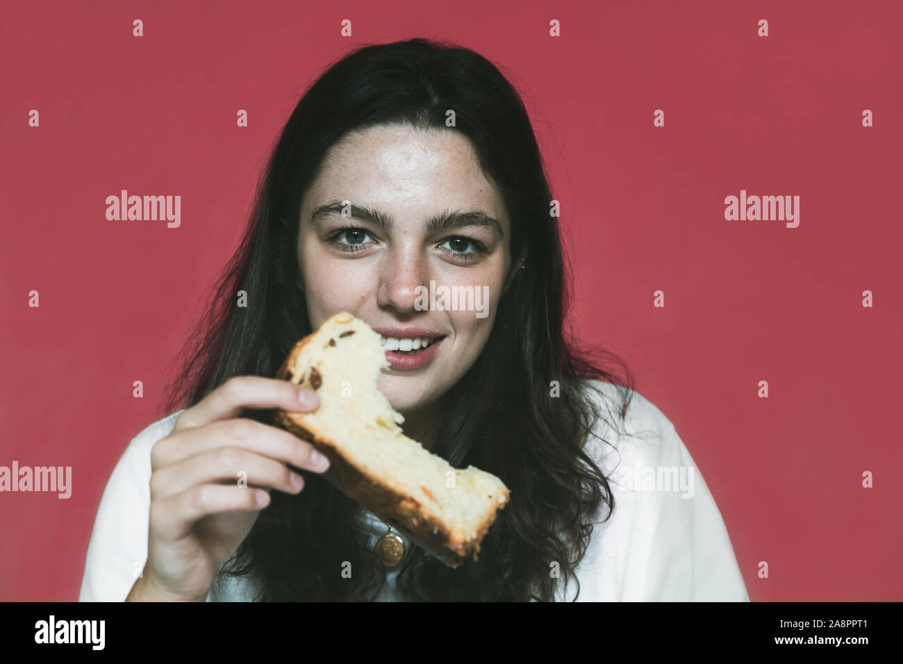 Giovane donna eting una fetta og panettone Foto Stock