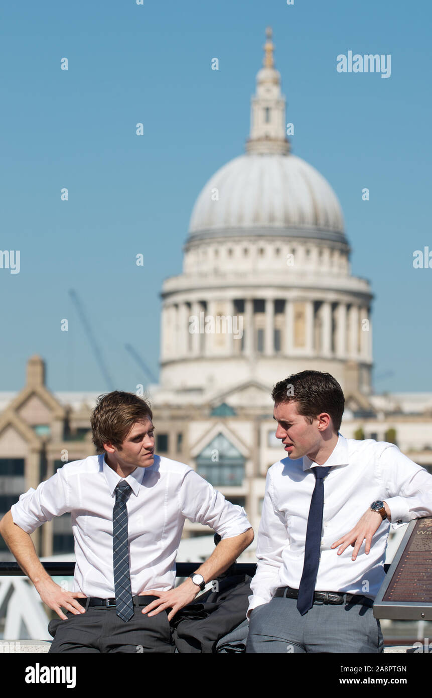 Londra - 28 SETTEMBRE 2011: Coppia di giovani uomini d'affari parlano davanti alla vista dello skyline della Cattedrale di Saint Paul sulla riva sud del Tamigi. Foto Stock