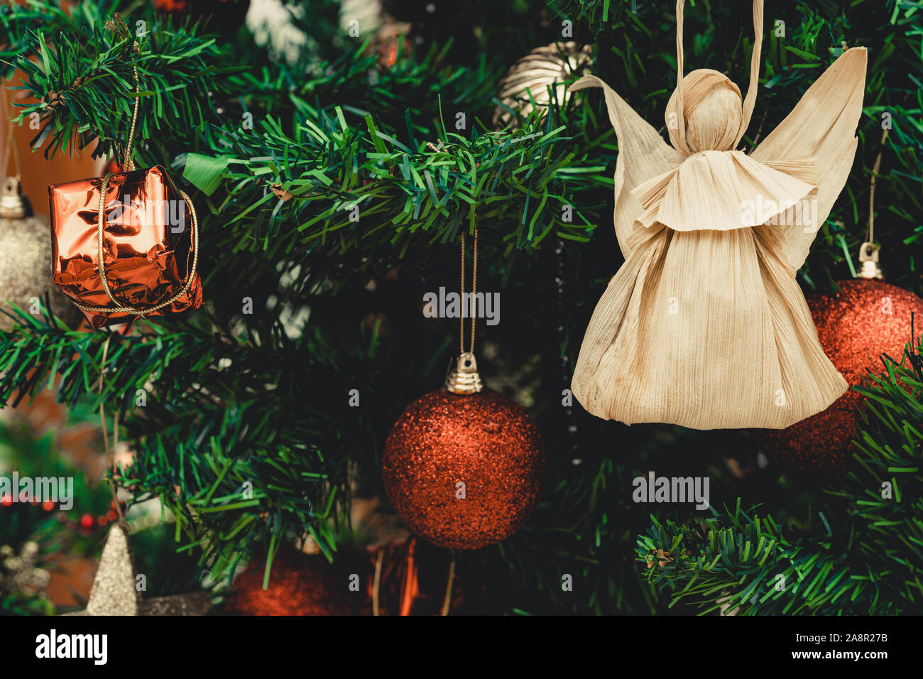 Corn buccia doll su albero di natale. Rosso e argento palle di Natale, baubles. La figura fatta da Corn buccia su albero di natale. Concetto di natale. Primo piano. Foto Stock