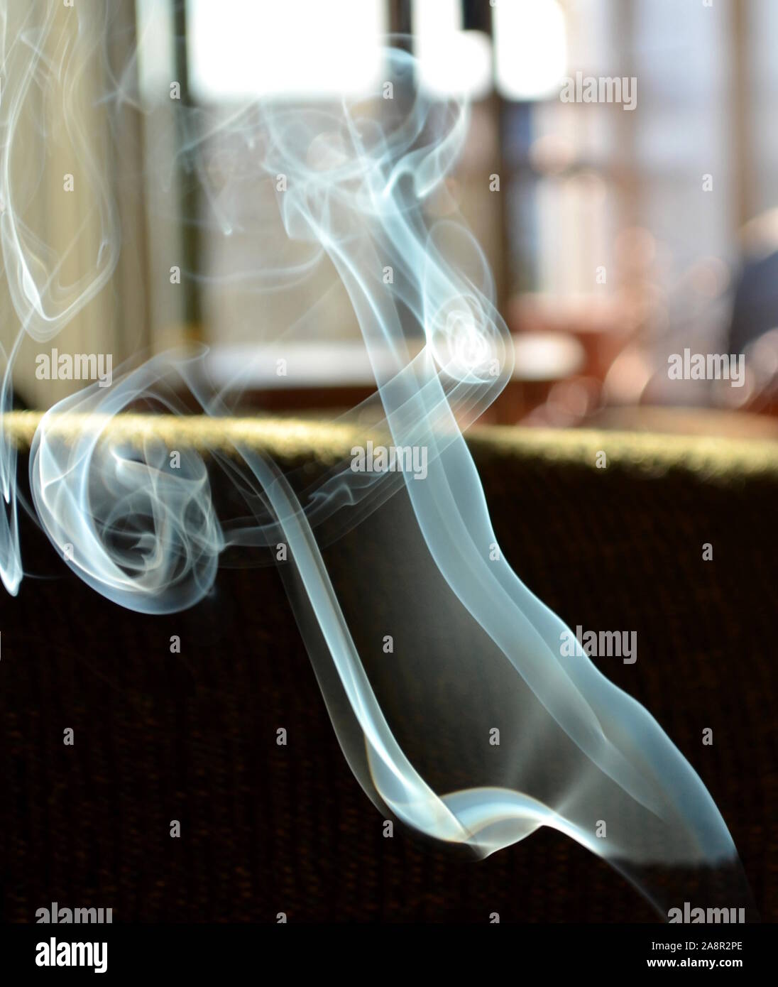 Incenso riccioli di fumo e di nastri nell'aria. Foto Stock