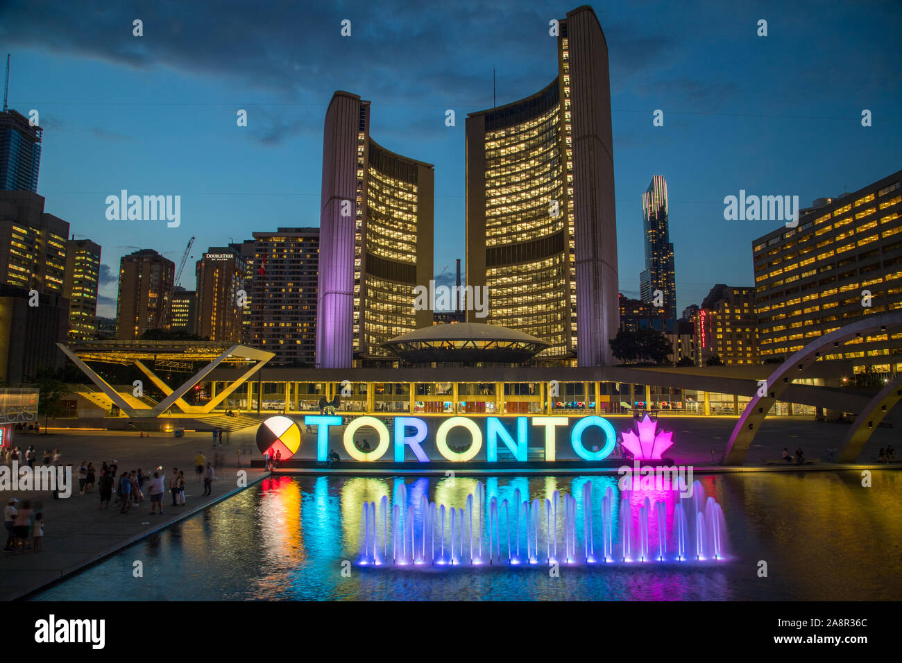 TORONTO, Canada - 17LUGLIO 2019: Il segno di Toronto a Nathan Phillips Square con il Municipio e altre architetture in background. Prese a nig Foto Stock