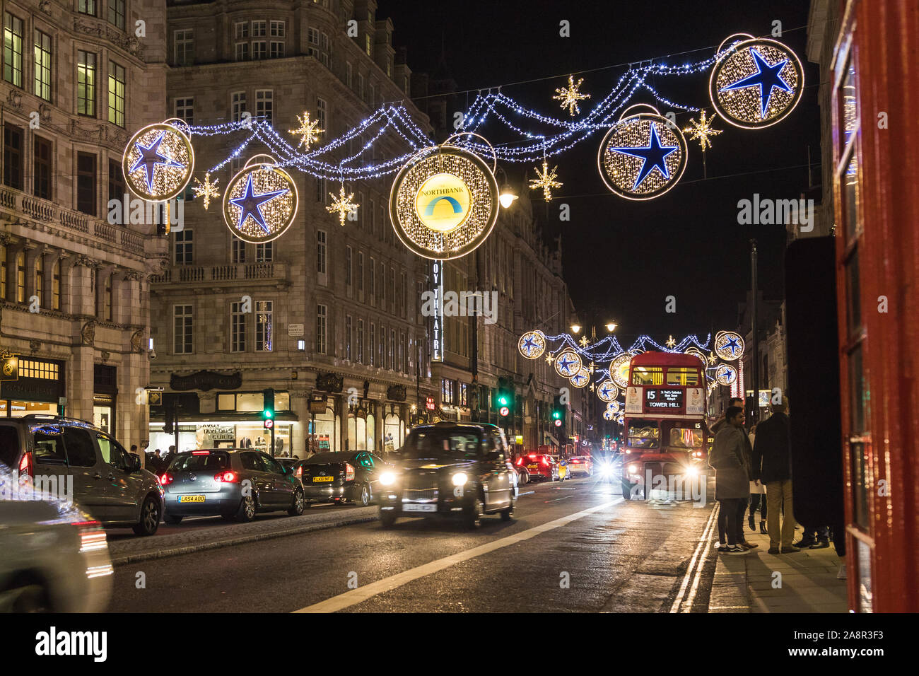 LONDON, Regno Unito - 17Novembre 2018: una vista lungo il filamento che mostra la Northbank decorazioni di Natale di notte. La gente può essere visto al di fuori. Foto Stock