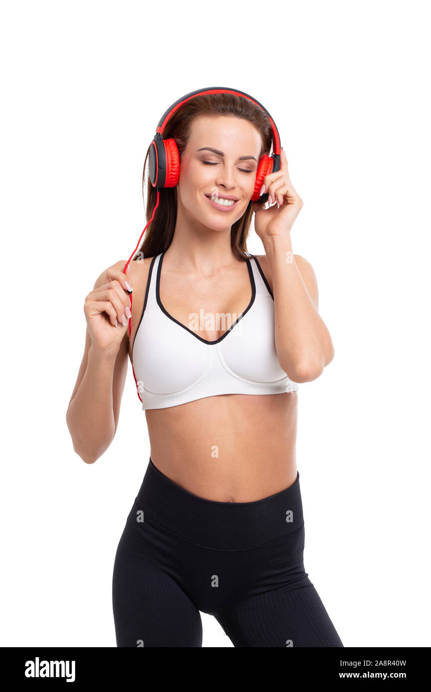 Giovane donna sportivo ascoltare musica tramite cuffie isolato su bianco Foto Stock