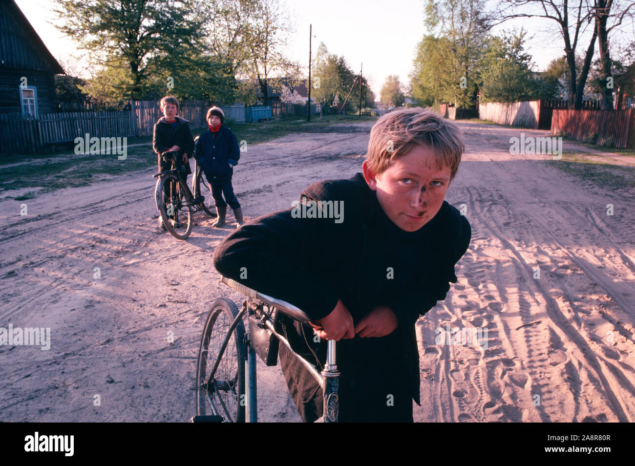 I ragazzi della scuola su una strada di sporco in Narodychi nella regione Polesia dell'Ucraina settentrionale. Narodychi era una delle aree più colpite dopo il 1986 incidente nucleare di Chernobyl. Foto Stock