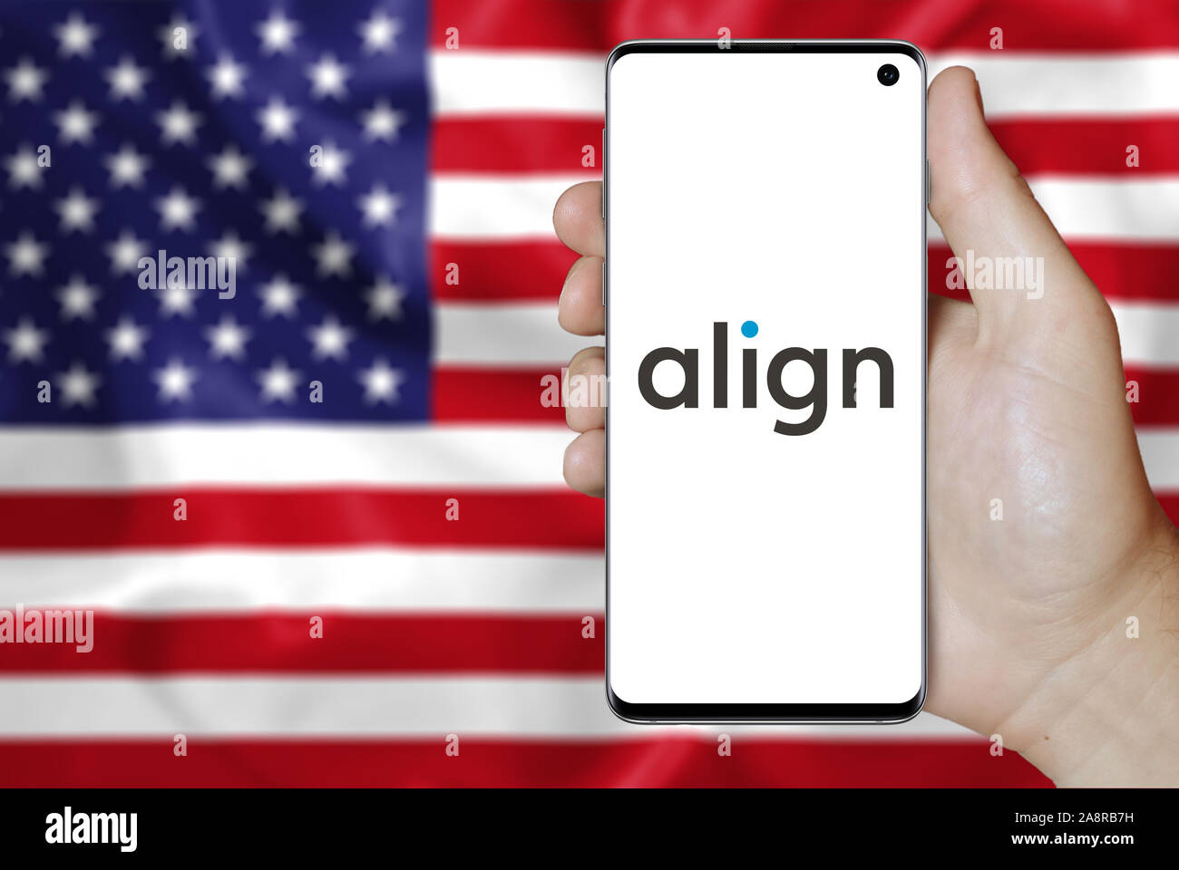 Il logo della società pubblica di Align Technology visualizzata su uno smartphone. Bandiera degli Stati Uniti sullo sfondo. Credito: PIXDUCE Foto Stock