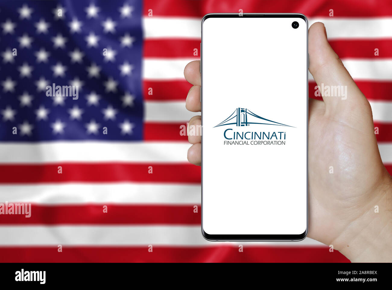 Il logo della società pubblica Cincinnati Financial visualizzata su uno smartphone. Bandiera degli Stati Uniti sullo sfondo. Credito: PIXDUCE Foto Stock