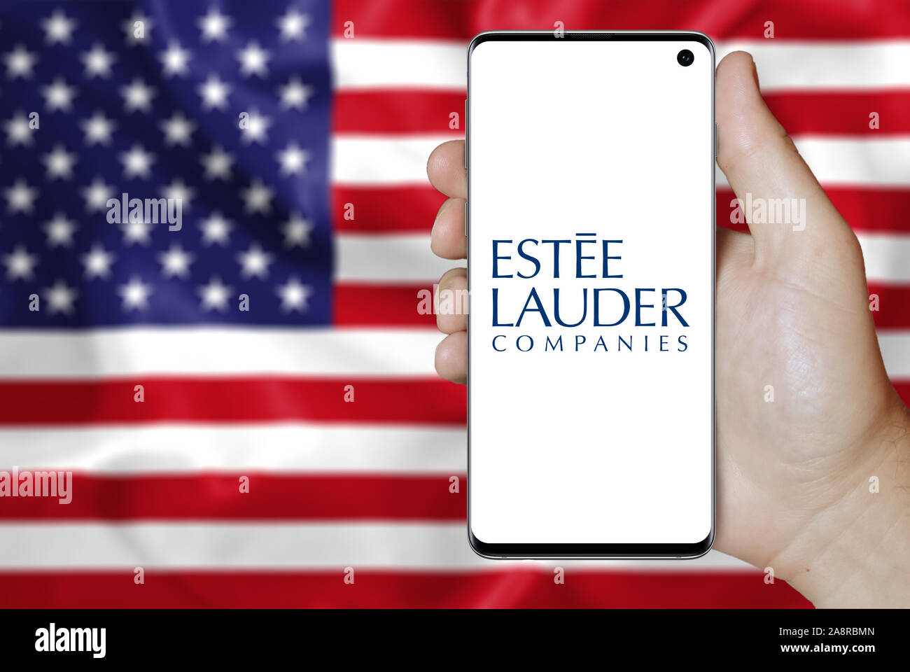 Il logo della società pubblica Estee Lauder Cos. visualizzata su uno smartphone. Bandiera degli Stati Uniti sullo sfondo. Credito: PIXDUCE Foto Stock