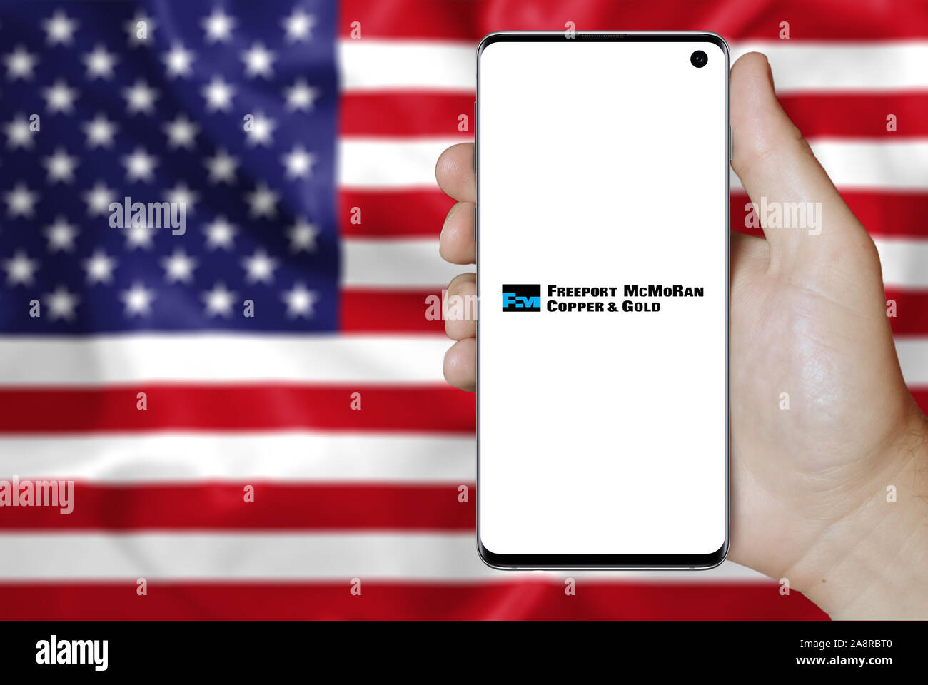 Il logo della società pubblica Freeport-McMoRan Inc. visualizzata su uno smartphone. Bandiera degli Stati Uniti sullo sfondo. Credito: PIXDUCE Foto Stock