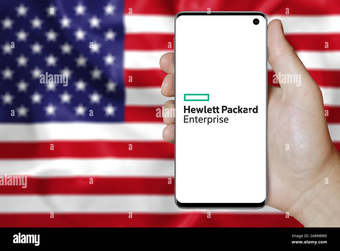 Il logo della società pubblica Hewlett Packard Enterprise visualizzata su uno smartphone. Bandiera degli Stati Uniti sullo sfondo. Credito: PIXDUCE Foto Stock