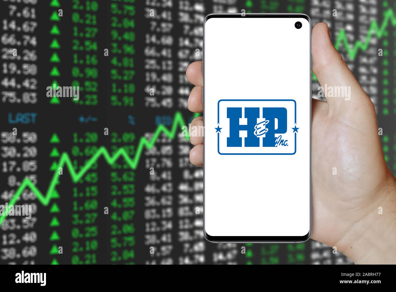Il logo della società pubblica Helmerich & Payne visualizzata su uno smartphone. Positivo del mercato azionario sfondo. Credito: PIXDUCE Foto Stock