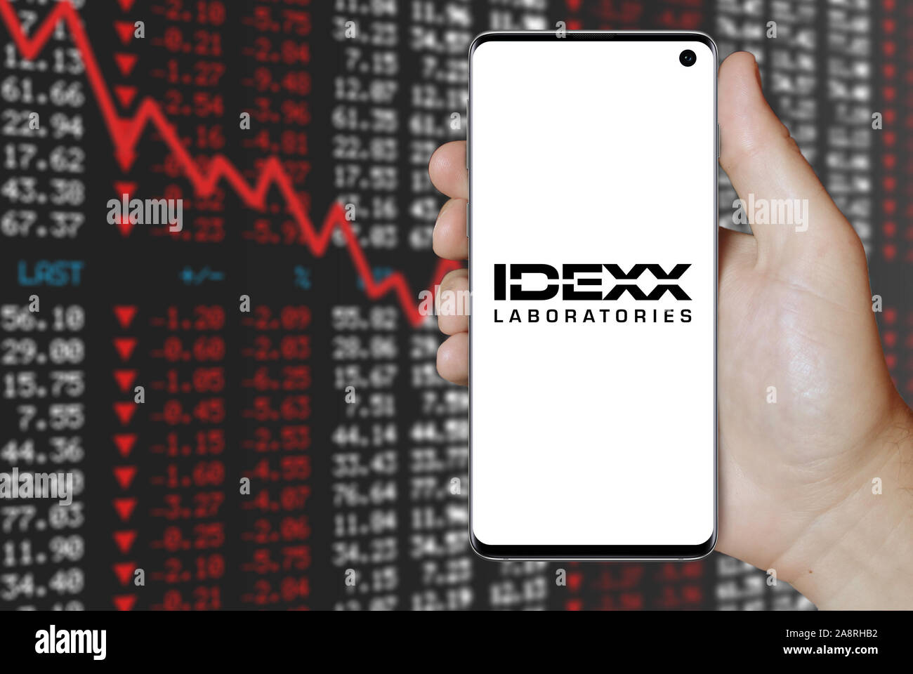 Il logo della società pubblica IDEXX Laboratories visualizzata su uno smartphone. Stock negativi sullo sfondo del mercato. Credito: PIXDUCE Foto Stock
