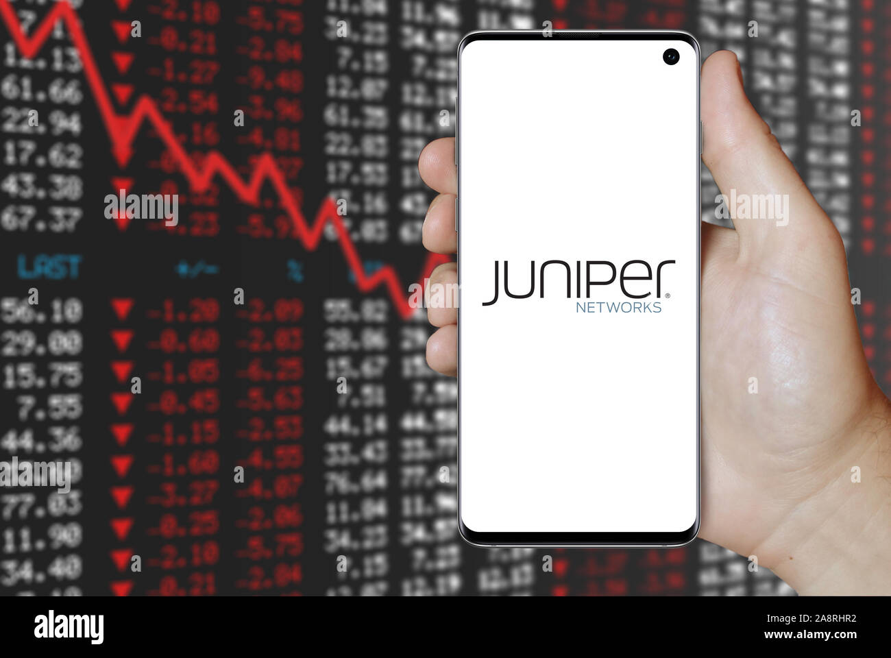 Il logo della società pubblica Juniper Networks visualizzata su uno smartphone. Stock negativi sullo sfondo del mercato. Credito: PIXDUCE Foto Stock