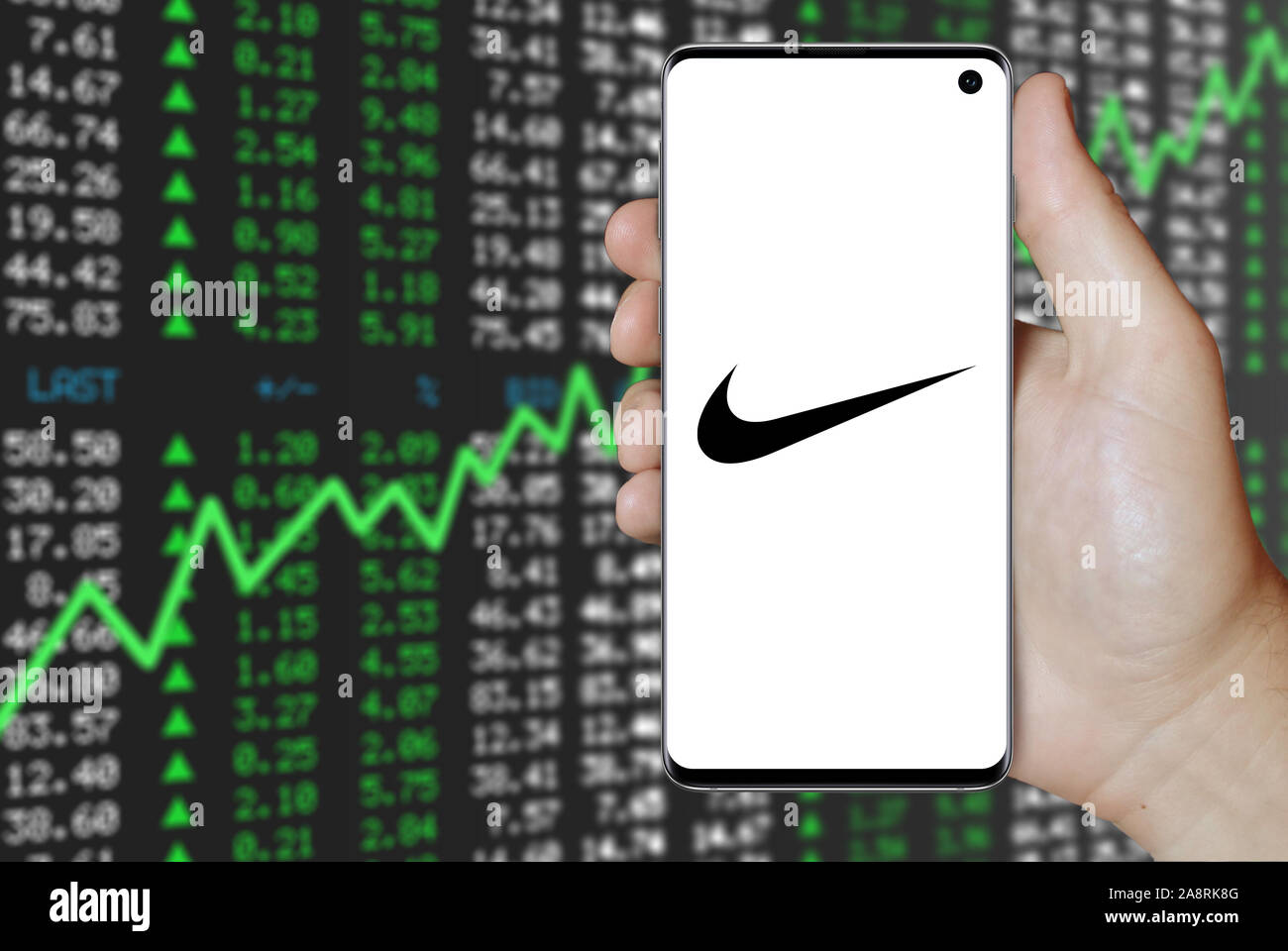 Il logo della società pubblica Nike visualizzata su uno smartphone. Positivo del mercato azionario sfondo. Credito: PIXDUCE Foto Stock