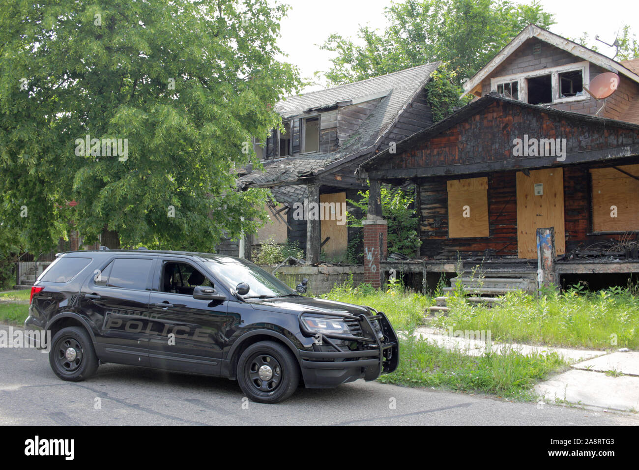 Detroit veicolo di polizia al di fuori di edifici in rovina, Detroit, Michigan, Stati Uniti d'America Foto Stock
