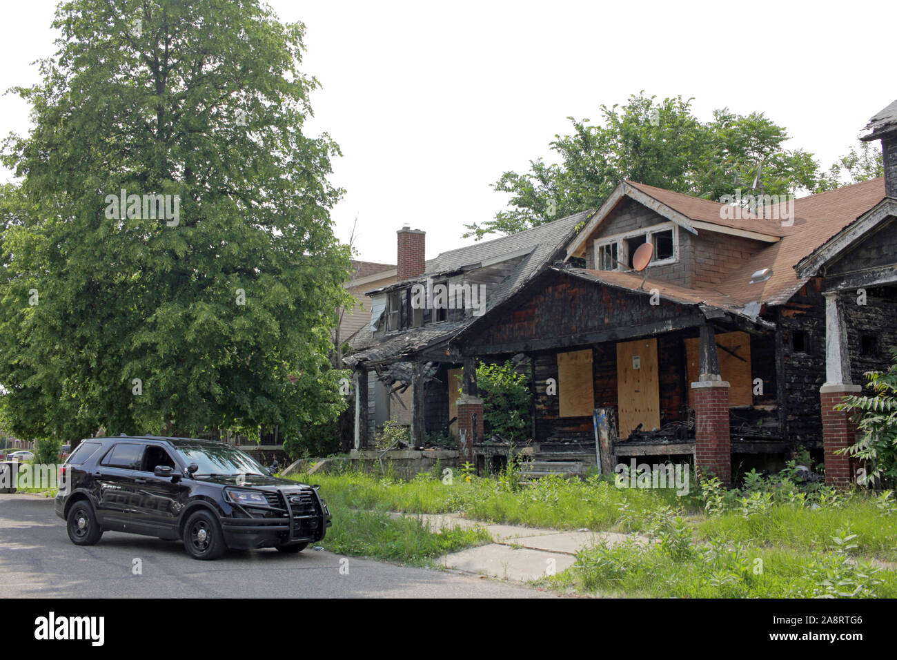Detroit veicolo di polizia al di fuori di edifici in rovina, Detroit, Michigan, Stati Uniti d'America Foto Stock