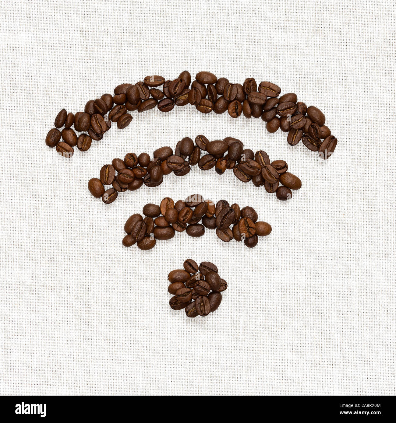 Simbolo Wi-Fi piegato da chicchi di caffè tostati sulla base di tela ruvida Foto Stock