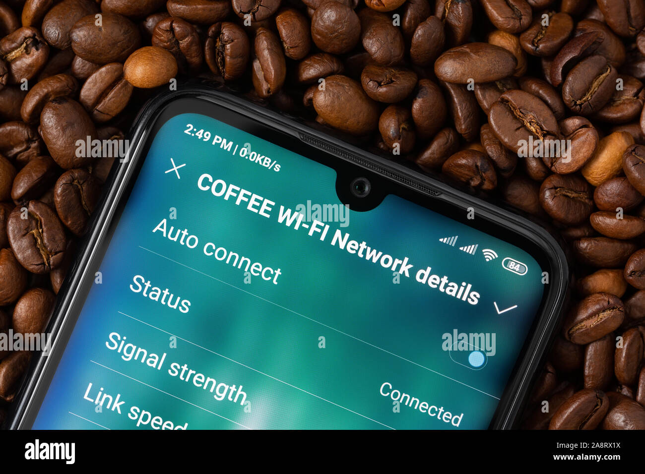 Uno smartphone con uno schermo per il collegamento alla rete Wi-Fi "Caffè' giace su di chicchi di caffè. L'accesso mobile a internet concetto in cafe. Foto Stock