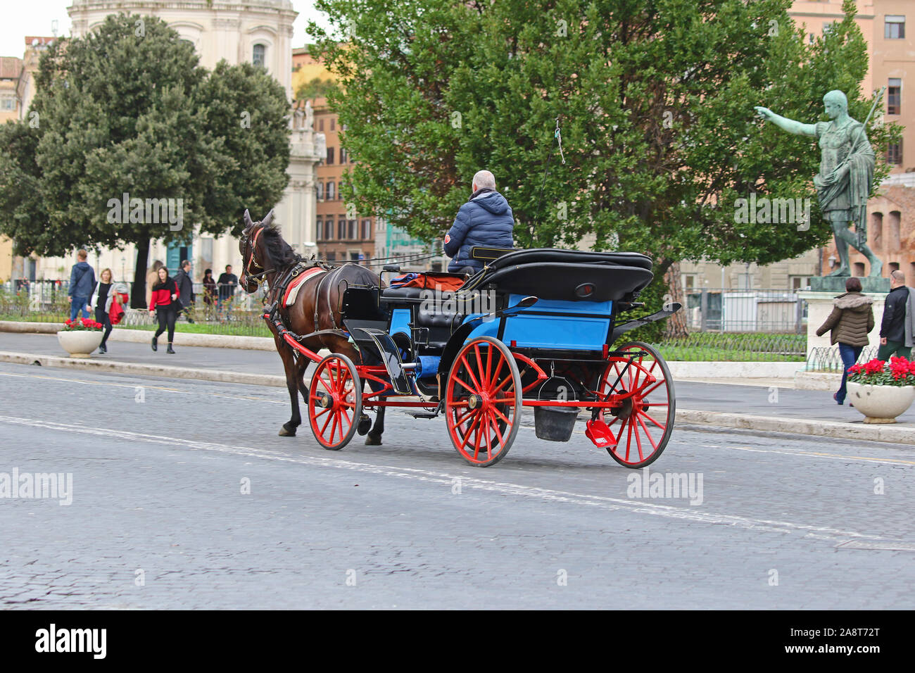 Una strada di Roma con la Roma antica e quella moderna e un cavallo e un carrello utilizzato per dare ai turisti un giro Foto Stock