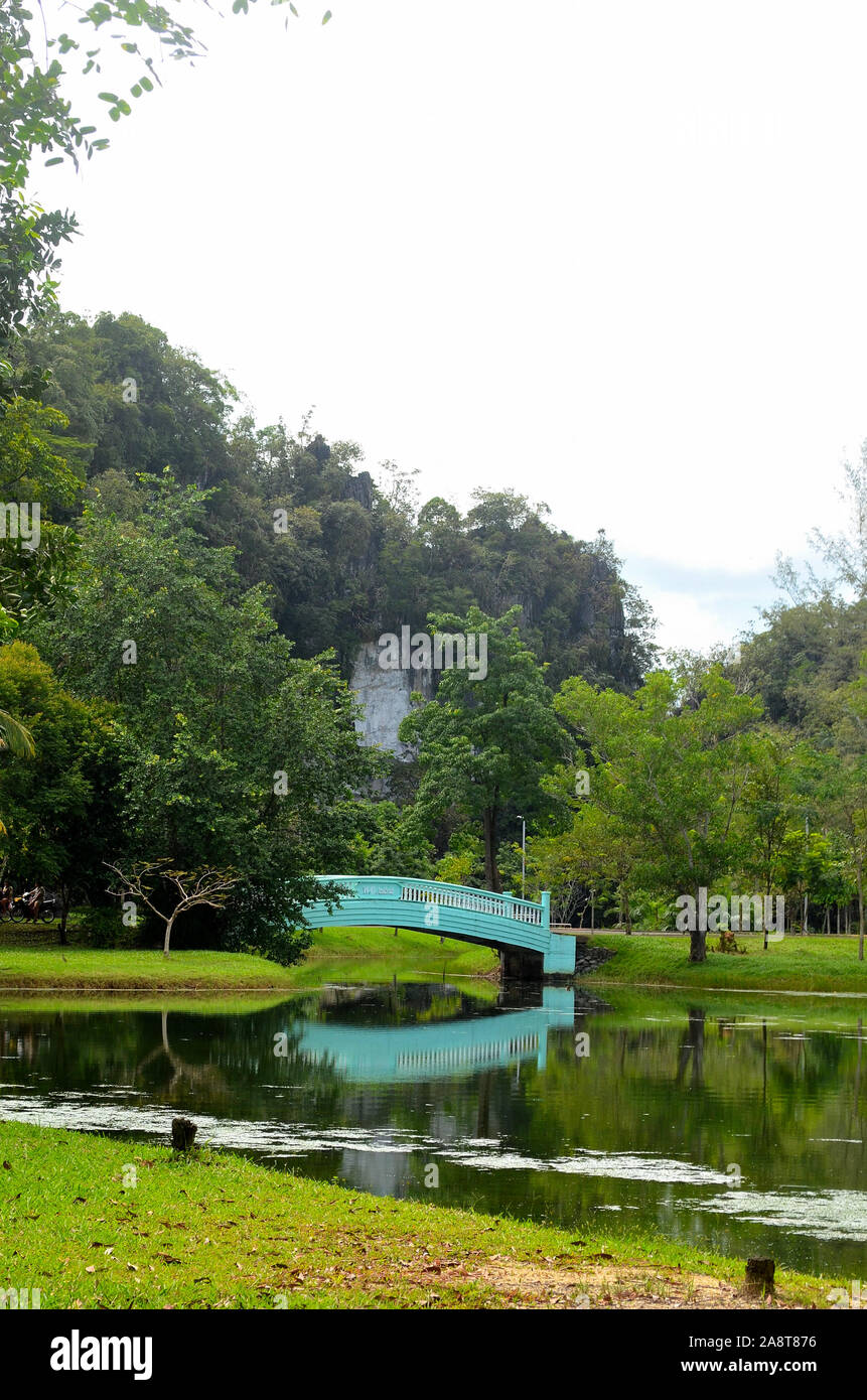 Un blue Bridge crossing l'ingresso al lago a Somdet Phra Srinagarinda Park con il suo riflesso nell'acqua cristallina a Phang Nga Città Foto Stock