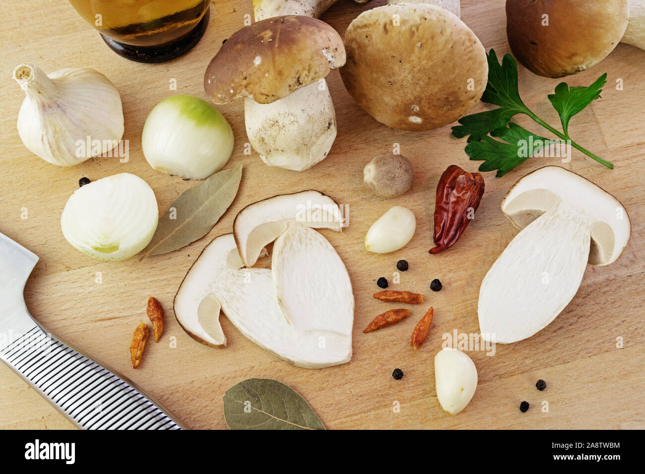 Affettato e intera di funghi porcini con alloro, noce moscata, aglio, cipolla, nero peperone e peperoncino su un tavolo di legno. Cucina, prelibatezze e cibo sano Foto Stock