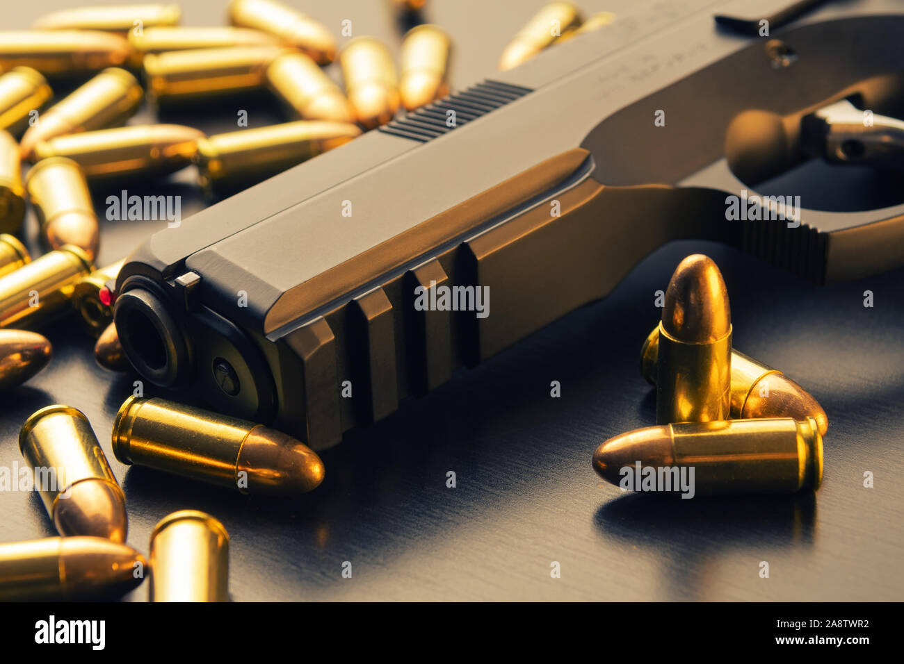 9 mm pistola semi-automatica con Full Metal Jacket proiettili sparsi sulla superficie nera. Mockup concettuale del controllo della pistola e la criminalità Foto Stock