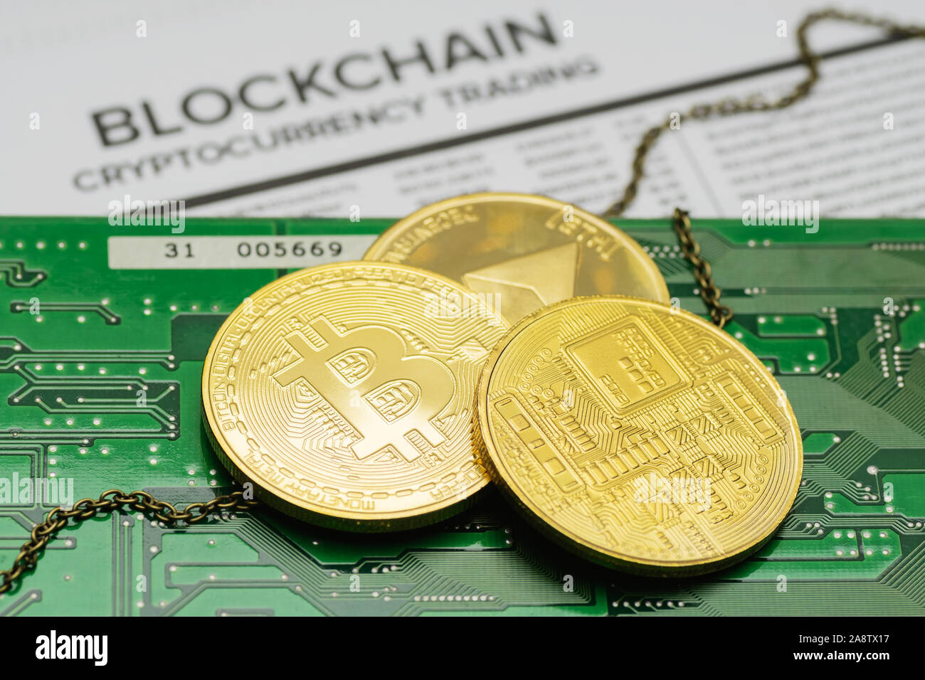 Primo piano della golden Bitcoin e Ethereum cryptocurrency monete con la catena sulla scheda a circuito stampato e mockup blockchain transazioni pagina elenco Foto Stock