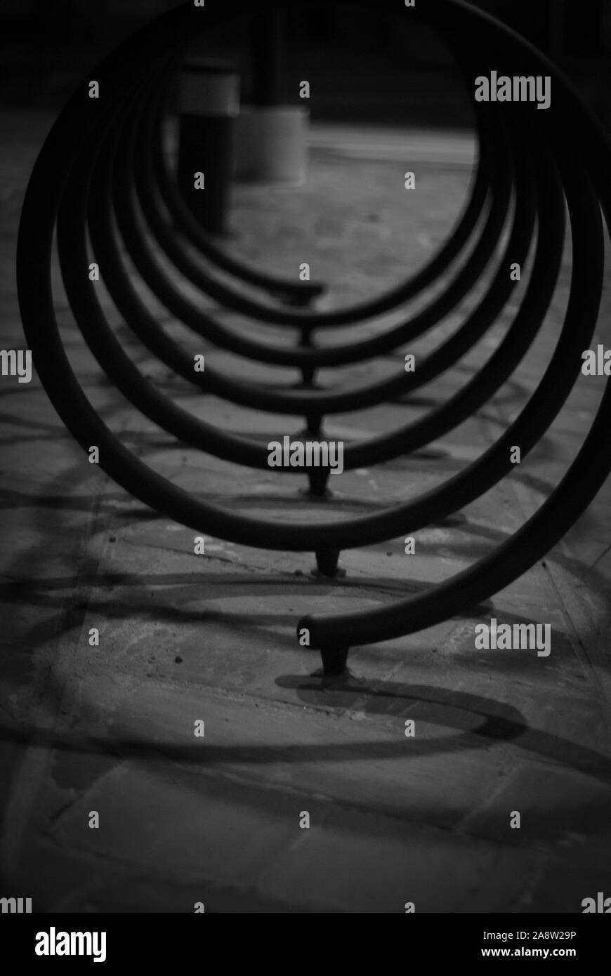 Scatti in bianco e nero, del supporto per biciclette, a forma di spirale e delle ombre che produce Foto Stock