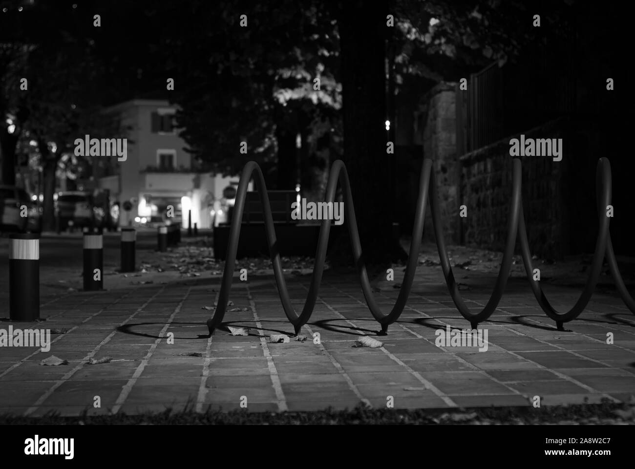 Notte scorcio di un sobborgo della città, tra alberi e foglie cadute, realizzata in bianco e nero nel periodo autunnale Foto Stock