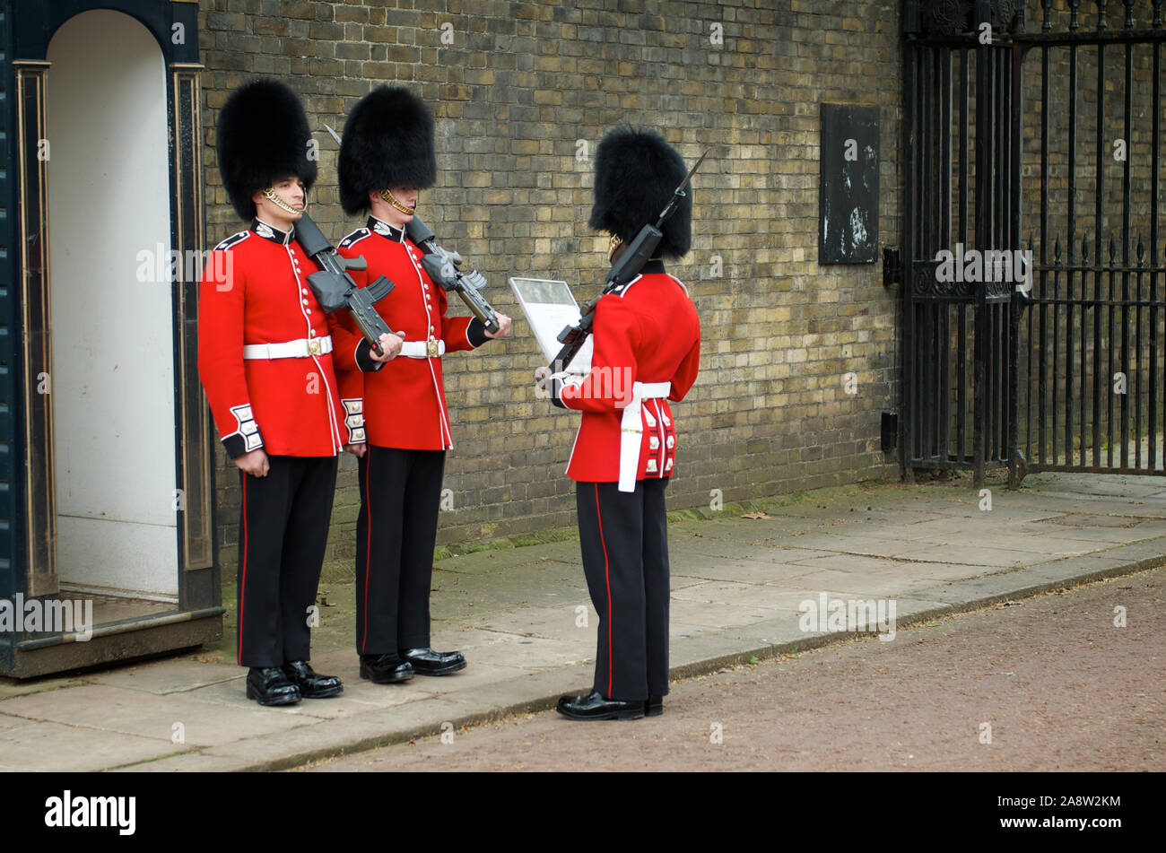 Londra - 6 MAGGIO 2012: Le guardie reali sono in piedi in giacche rosse tradizionali e cappelli busby, che sono fatti con pelliccia dalla barba marrone canadese. Foto Stock