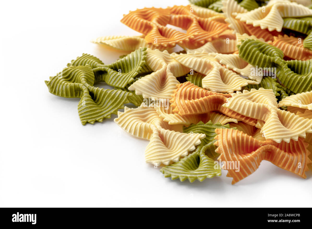 Farfalle close up macro mostra strappato pasta di prua, tri-isolato di color bianco sulla messa a fuoco selettiva di sfondo per copia di spazio o di sovrapposizione di testo Foto Stock