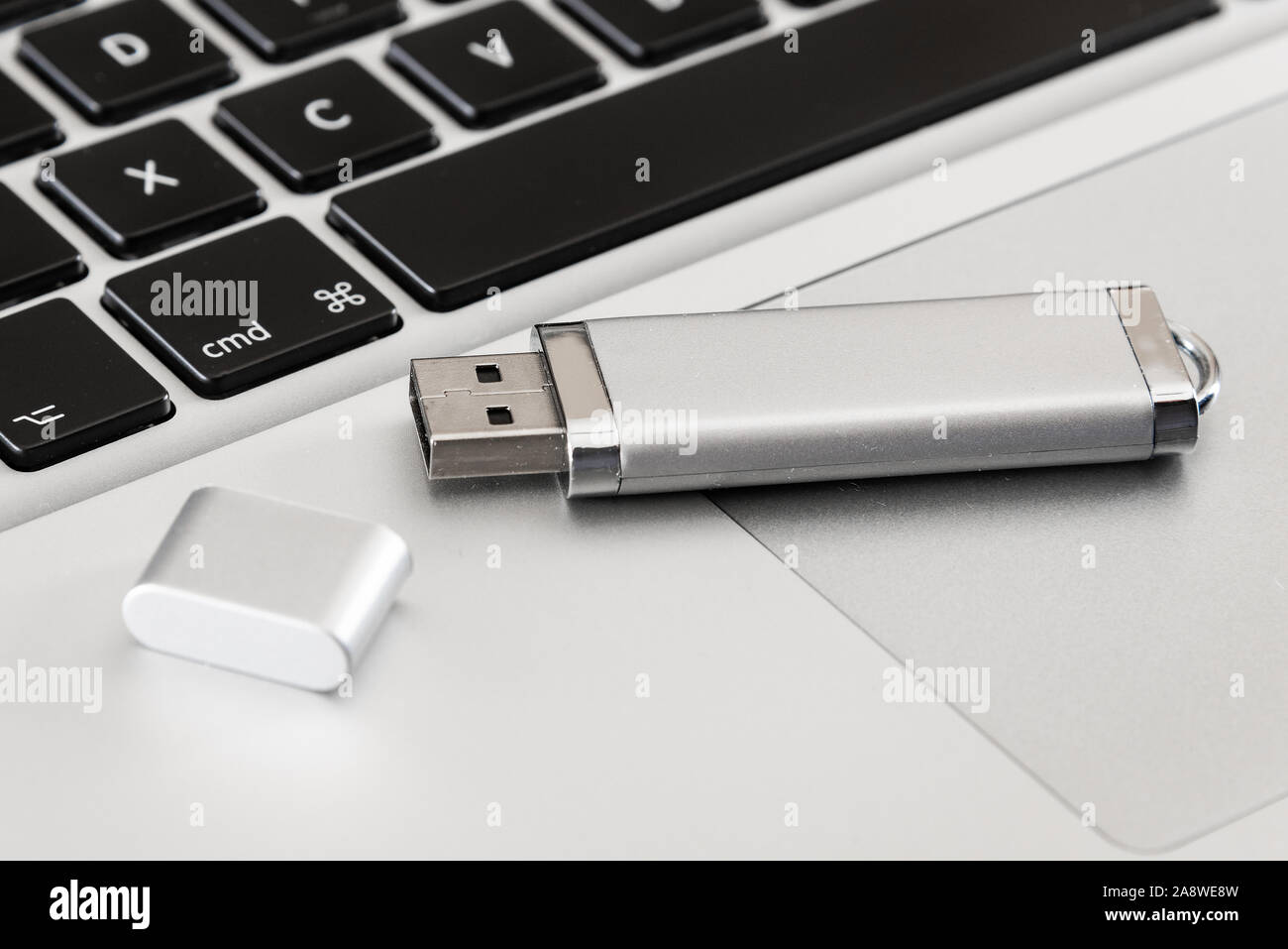 Un argento drive flash USB con un computer portatile. Foto Stock