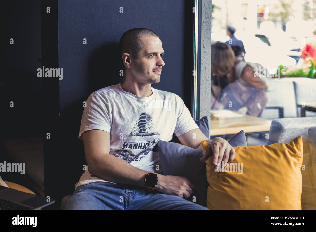 Uomo seduto in cafe e guardando lontano nella finestra Foto Stock