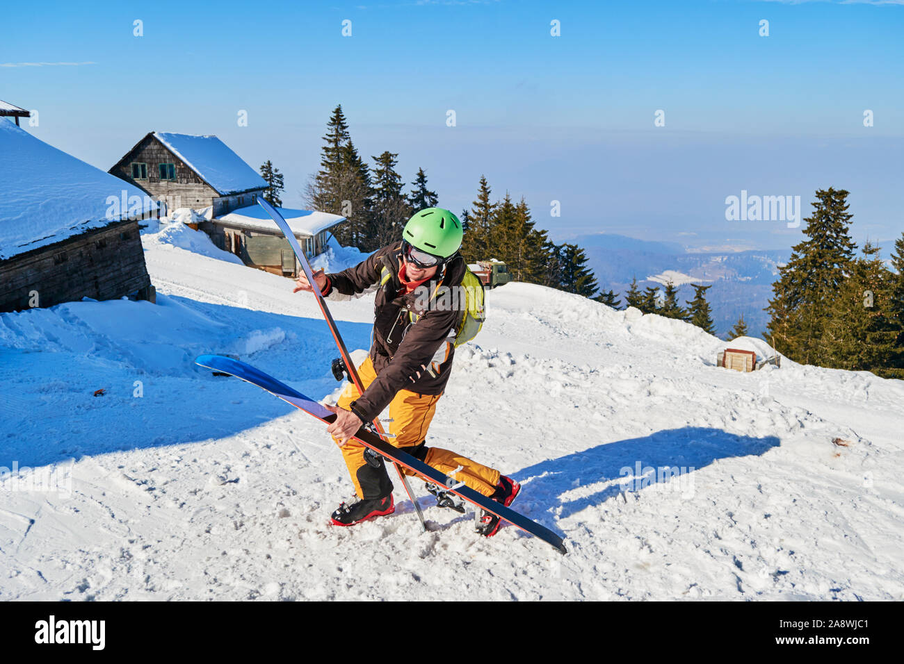 Clumsy funny sciatore facendo cadere la sua ampia sci. Posizione: Poiana Brasov ski resort, Romania. Foto Stock