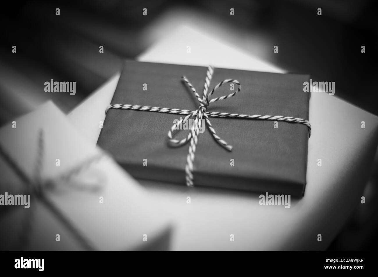 Bianco e nero regali di Natale su sfondo sfocato Foto Stock