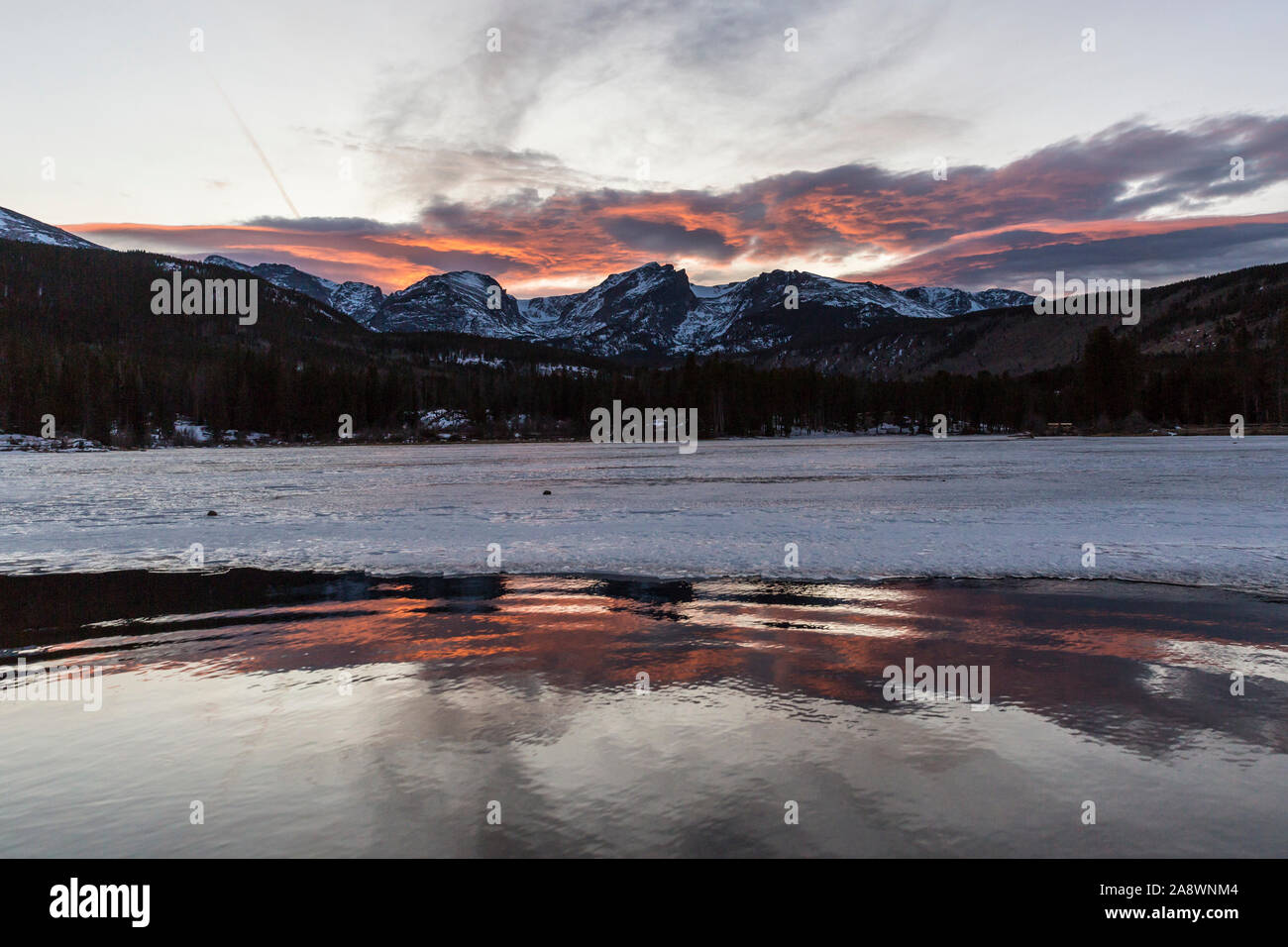 Un bel tramonto oltre le montagne che si affacciano sul lago Sprague nel Parco Nazionale delle Montagne Rocciose in Colorado. Foto Stock