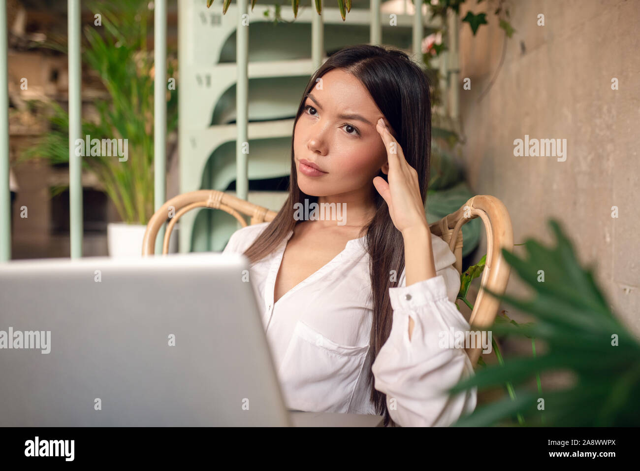 Imprenditrice avente mal di testa dopo il lavoro per un periodo di tempo troppo lungo Foto Stock