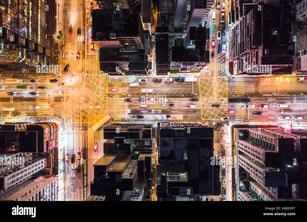 Auto, taxi e autobus di traffico su strada intersezione di notte a Hong Kong downtown district, antenna fuco vista dall'alto. Street commuter Asia la vita della città di concetto Foto Stock