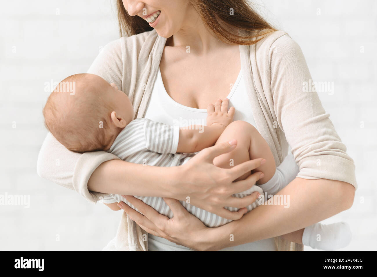 Azienda madre neonato Bambino in mani lulling lui dormire Foto Stock
