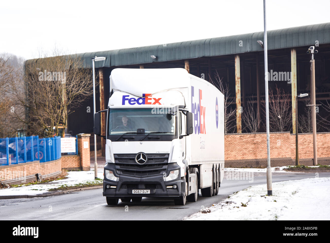 Fed Ex autocarri pronto avente la manutenzione e di essere caricato con i pacchi che devono essere consegnati in tutto il paese e il mondo, veicoli pesanti, logistica Foto Stock