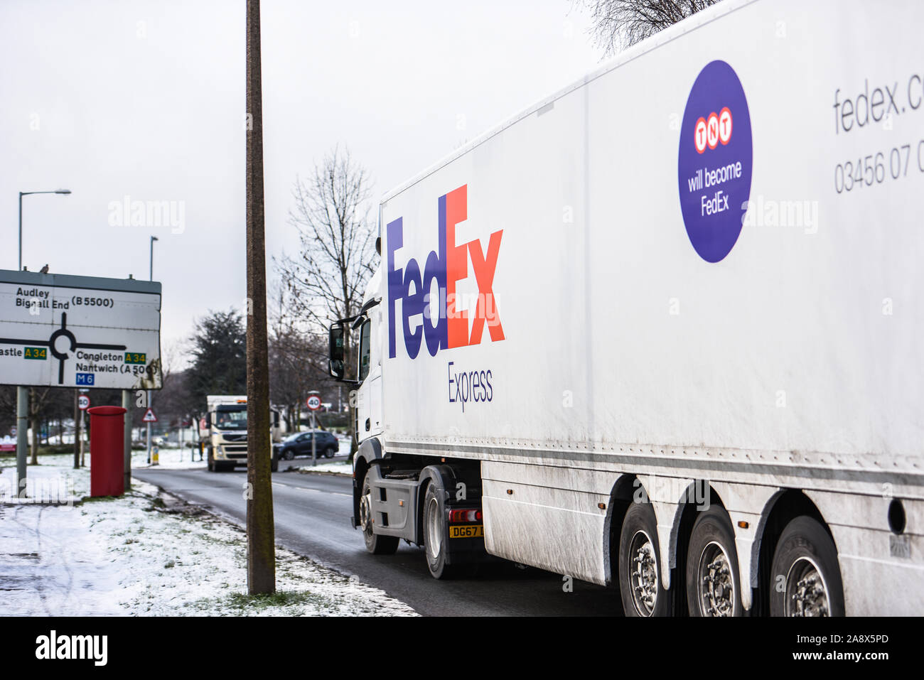 Fed Ex autocarri pronto avente la manutenzione e di essere caricato con i pacchi che devono essere consegnati in tutto il paese e il mondo, veicoli pesanti, logistica Foto Stock