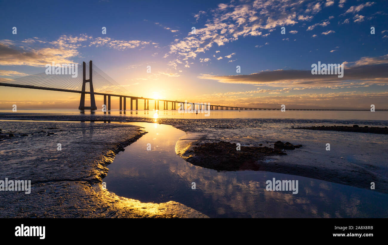 Dal ponte Vasco da Gama a sunrise a Lisbona, Portogallo. Dal ponte Vasco da Gama è un cavo-alloggiato bridge affiancato da viadotti e rangeviews che abbraccia il T Foto Stock