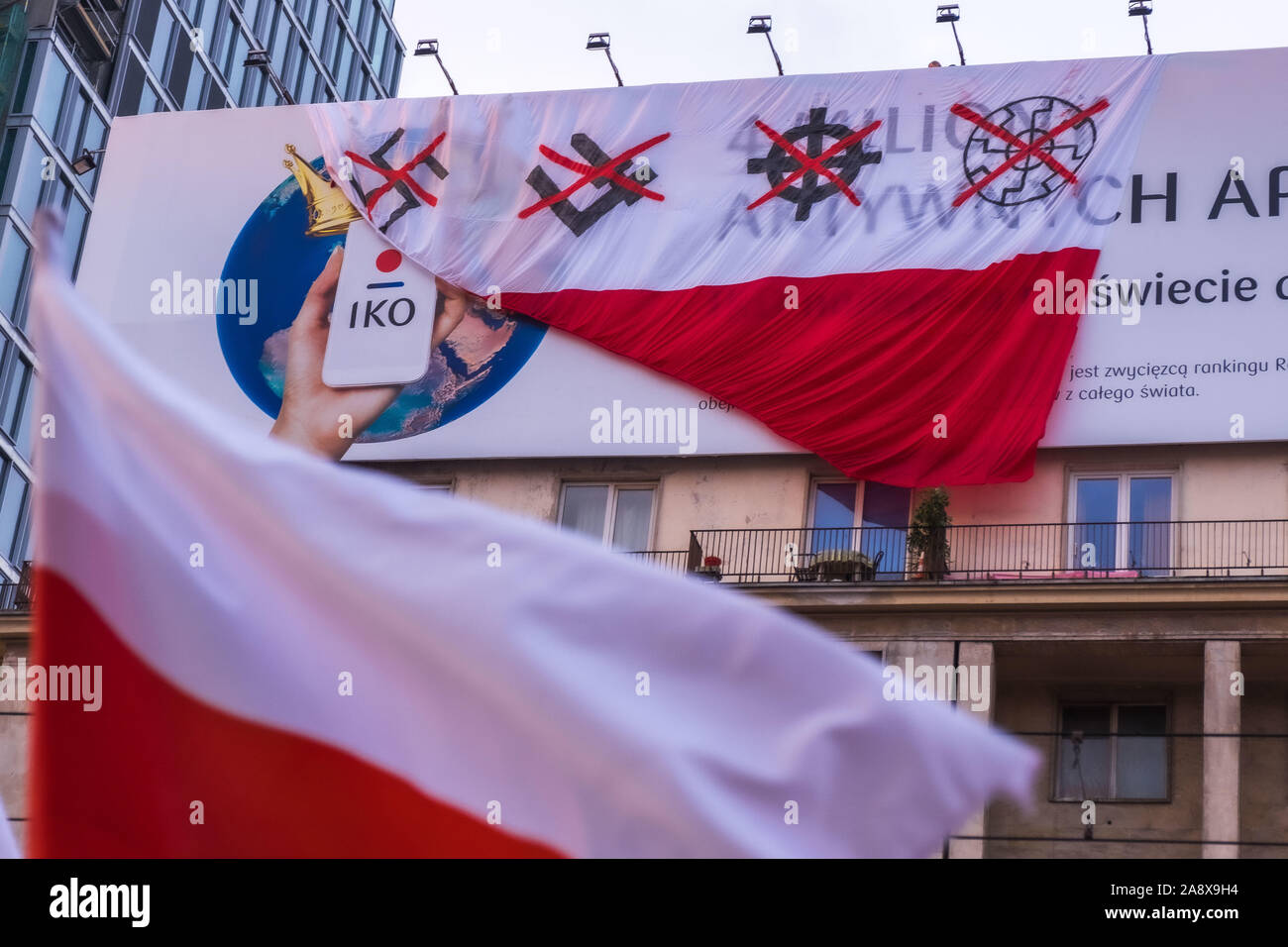 11 novembre 2019: Anti-attivisti nazionalisti sono appesi bandiera polacca con barrata nazista e fascista simboli durante l'indipendenza marzo il giorno di indipendenza che raccoglie decine di migliaia di persone ogni anno. Protestano contro la xenofobia e il nazionalismo radicale che è come entrare nella politica mainstream in Polonia. Per la prima volta mai ''Konfederacja'' ala destra, anti-semita,omofobi, radicale partito nazionalista ha preso 11 fuori di 460 seggi in parlamento polacco in elezioni di ottobre. (Credito Immagine: © Robert Pastryk/ZUMA filo) Foto Stock