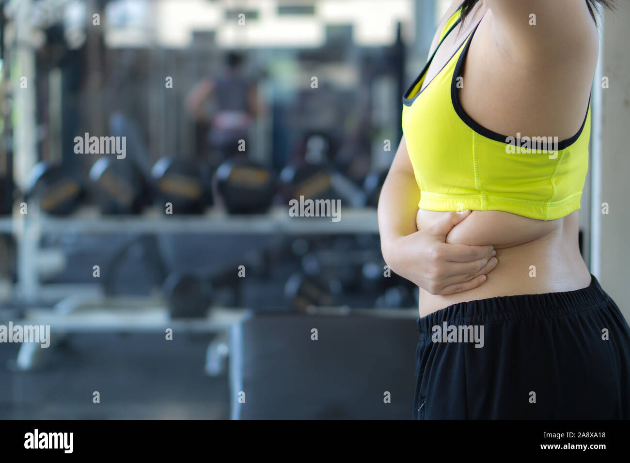 Close up donna tenendo il grasso eccessivo inferiore sul retro. Donna sovrappeso addome. Dieta donna il concetto di stile di vita ridurre la pancia e forma fino sano stomaco musc Foto Stock
