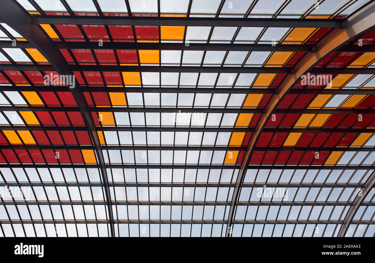 Vista ravvicinata di un soffitto realizzato con rosso, giallo e vetri trasparenti e struttura in metallo. Foto Stock