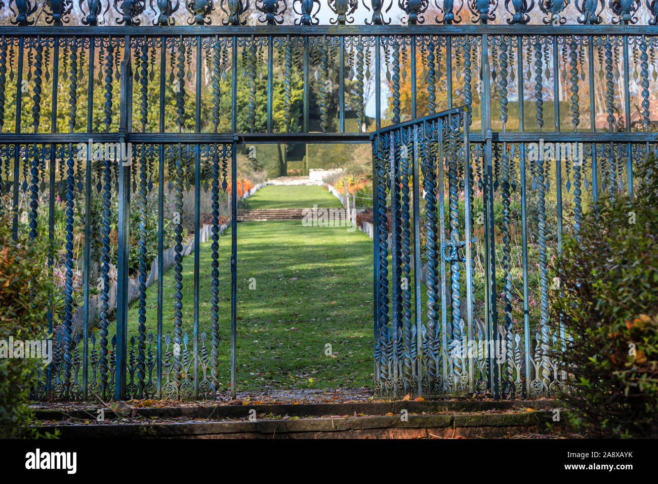 Un gateway in un metallo ornati di recinzione da giardino Foto Stock