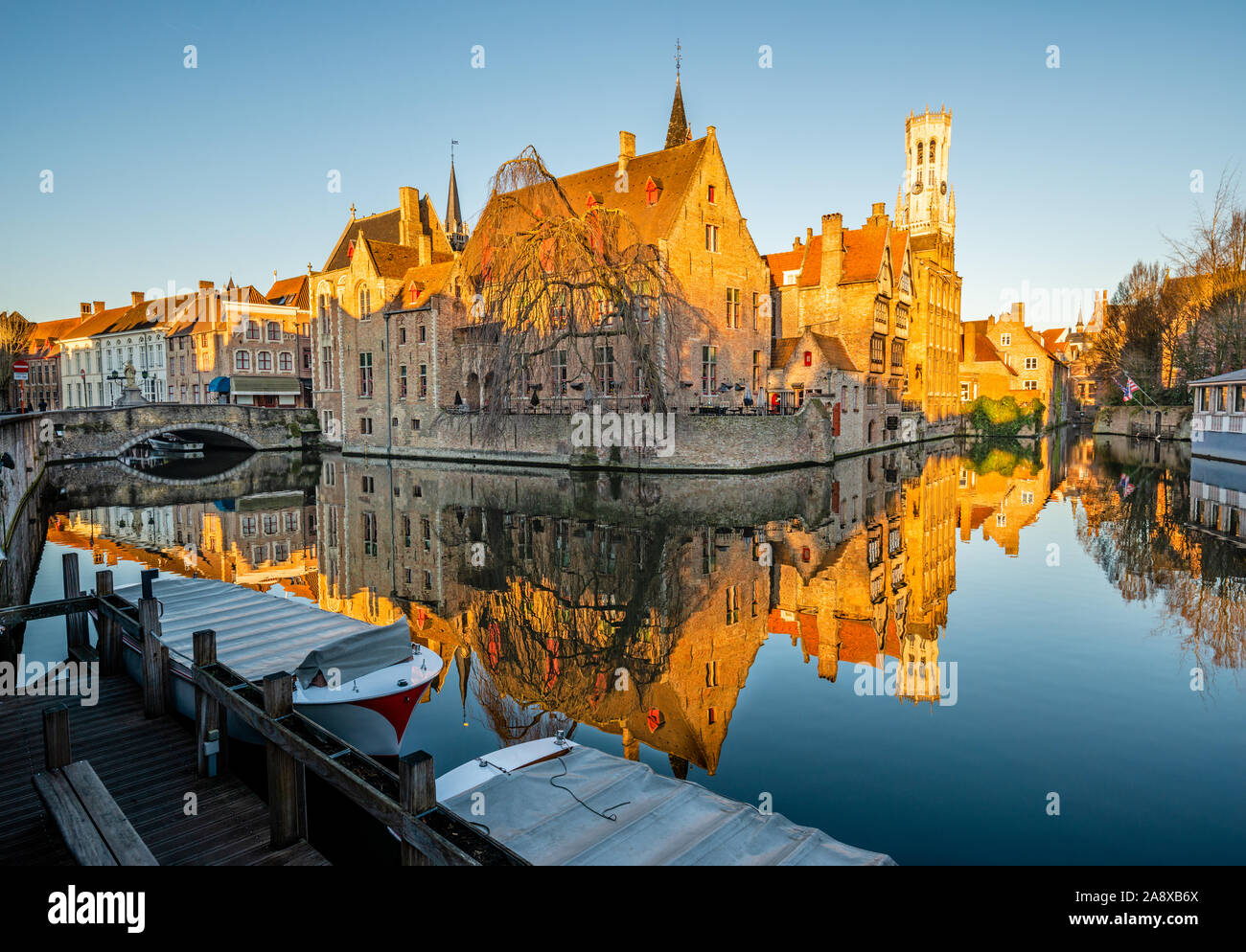 La mattina presto fotografia di un canale in Bruges, con vista sulla chiesa di Nostra Signora Foto Stock