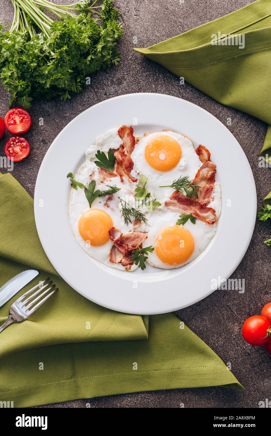 Tostare le uova con bacon su un piatto bianco. Foto Stock