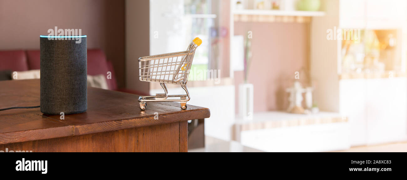 Carrello con altoparlante e riconoscimento vocale. Seduto in soggiorno e shopping comodamente su internet. Devi semplicemente acquistare le merci a voce. Foto Stock